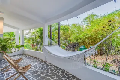 a hammock on the porch of a house at Nosara Beach Hotel in Nosara