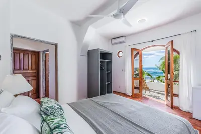 a bedroom with a bed and a view of the ocean at Nosara Beach Hotel in Nosara