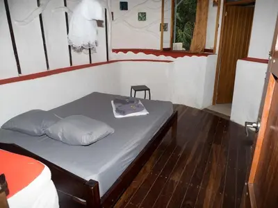 a bedroom with a bed with a pillow on it at Poolvilla in Platanillo
