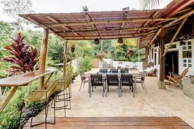 a patio with a wooden pergola and a table and chairs at Poolvilla in Platanillo
