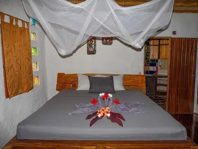 a bedroom with a bed with a flower on it at Poolvilla in Platanillo