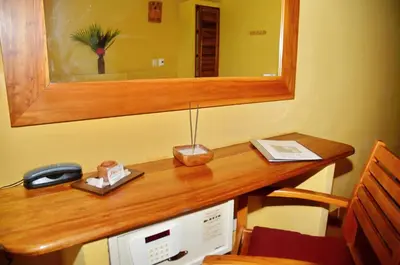 a desk with a mirror and a telephone and a computer at Esencia Hotel and Villas in Santa Teresa Beach