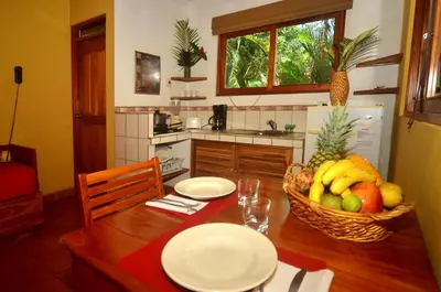 a kitchen with a wooden table with a basket of fruit at Esencia Hotel and Villas in Santa Teresa Beach