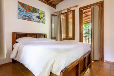 a bedroom with a large bed and a window at Rancho Margot Sustainable & Self Sufficient Eco Lodge in El Castillo de La Fortuna