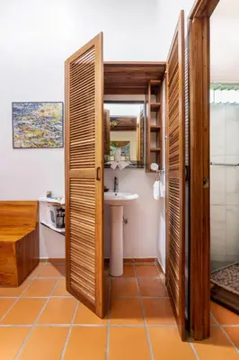 a bathroom with a sink and a toilet and a mirror at Rancho Margot Sustainable & Self Sufficient Eco Lodge in El Castillo de La Fortuna