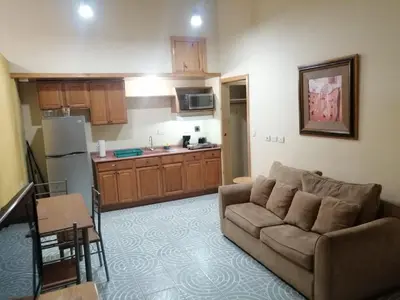 a living room with a couch and a kitchen at Apartotel Don Francisco in San José