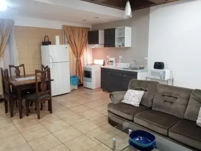 a living room with a couch and a table and a kitchen at Apartotel Don Francisco in San José