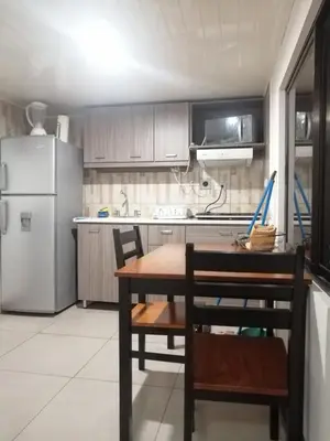 a kitchen with a table and a refrigerator at Apartotel Don Francisco in San José
