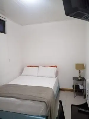 a bedroom with a bed in a white room at Apartotel Don Francisco in San José