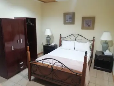 a bedroom with a bed with two night stands and two lamps at Apartotel Don Francisco in San José
