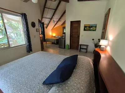 a bedroom with a bed with a blue pillow on it at Cabañas Cañas Castilla in La Cruz