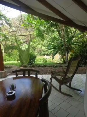 a wooden table and chairs on a patio at Cabañas Cañas Castilla in La Cruz