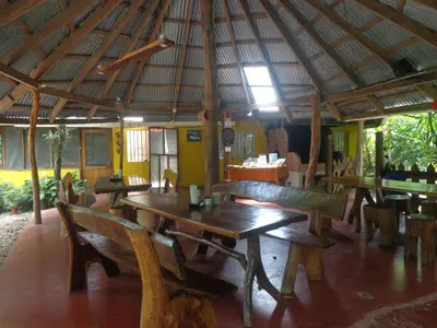 a restaurant with wooden tables and benches in a room at Cabañas Cañas Castilla in La Cruz