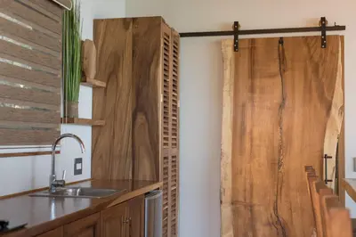 a kitchen with wooden doors and a sink at Vista del Alma Boutique - Adult Only in Santa Teresa Beach
