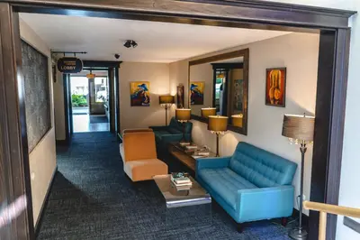 a living room with a blue couch and chairs at KC Hotel San Jose in San José