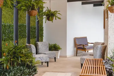 a patio with chairs and a table and plants at KC Hotel San Jose in San José