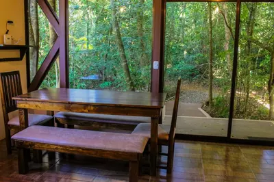 a wooden table and chairs in a room with a window at Quality Cabins Monteverde in Monteverde Costa Rica
