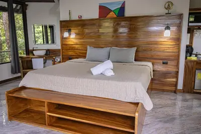 a bedroom with a large bed with a wooden headboard at Quality Cabins Monteverde in Monteverde Costa Rica