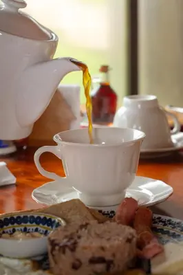 a teapot pouring tea into a cup on a table at Nafre House B&B Monteverde in Monteverde Costa Rica