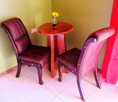 two chairs and a table and a table with a vase at Nafre House B&B Monteverde in Monteverde Costa Rica