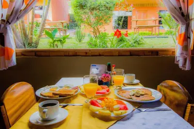a table with plates of food and drinks on it at Hotel Cipreses in Monteverde Costa Rica