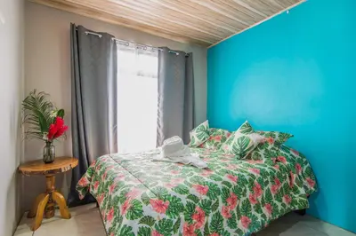 a bedroom with a bed and a blue wall at Casa Monarca II - Monteverde in Monteverde Costa Rica
