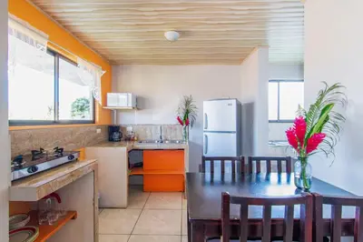 a kitchen with a refrigerator and a table with chairs at Casa Monarca II - Monteverde in Monteverde Costa Rica