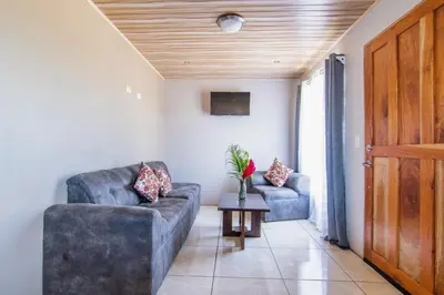 a living room with two couches and a table at Casa Monarca II - Monteverde in Monteverde Costa Rica