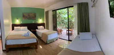 a bedroom with two beds and a balcony at Tirimbina Rainforest Lodge in Sarapiquí