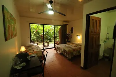 a bedroom with a bed and a table and a window at Tirimbina Rainforest Lodge in Sarapiquí