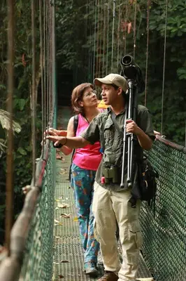a man and a woman standing on a suspension bridge at Tirimbina Rainforest Lodge in Sarapiquí