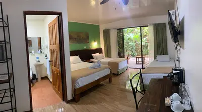 a hotel room with two beds and a mirror at Tirimbina Rainforest Lodge in Sarapiquí