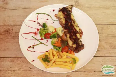 a plate of food with fries and meat and vegetables at Tirimbina Rainforest Lodge in Sarapiquí