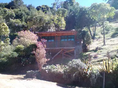 a house on the side of a hill with trees at Las Cataratas Lodge in San Gerardo de Dota