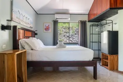 a bedroom with a large bed and a large window at Bongo - Adults Only in Manuel Antonio
