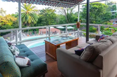 a living room with couches and a table and a pool at Bongo - Adults Only in Manuel Antonio