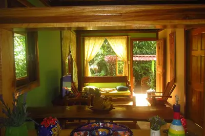 a living room with a couch and a window at casa chilamates in Tortuguero