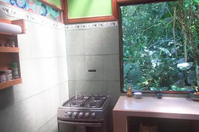 a kitchen with a stove and a window at casa chilamates in Tortuguero