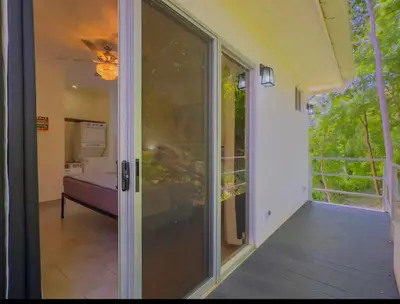 a glass door leading to a balcony with a bed at Gorgeous Ocean View Private home, 4 bedrooms with en suite, private plunge pool in Coco