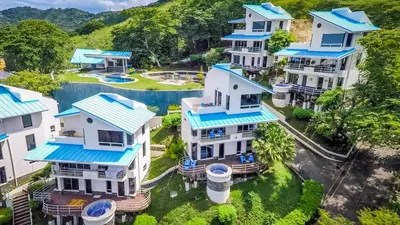 an aerial view of a house with blue roofs at Gorgeous Ocean View Private home, 4 bedrooms with en suite, private plunge pool in Coco