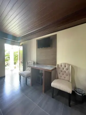 a room with a desk and two chairs and a television at Campos Arenal Hotel in Fortuna