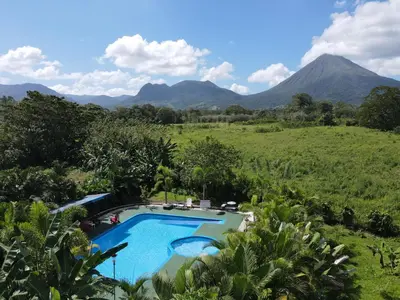 a swimming pool with a mountain in the background at Campos Arenal Hotel in Fortuna