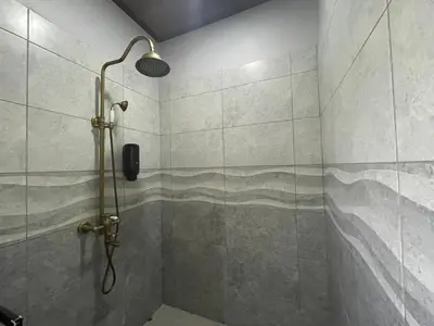 a shower with a shower head in a bathroom at Campos Arenal Hotel in Fortuna