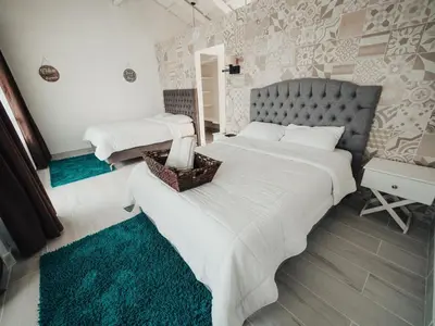 a bedroom with two beds with white sheets at Hotel Arenal Vista Lodge in Fortuna