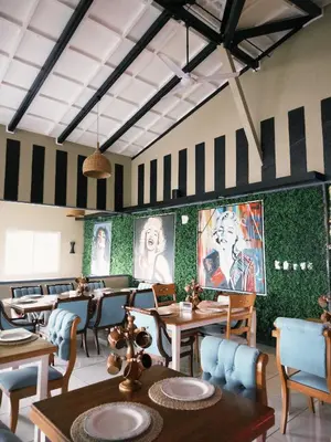 a restaurant with tables and chairs and pictures on the walls at Hotel Arenal Vista Lodge in Fortuna