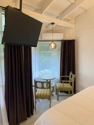 a bedroom with a bed and a table and chairs at Hotel Arenal Vista Lodge in Fortuna