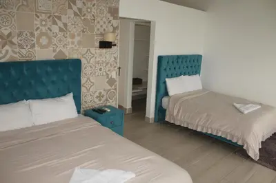 a bedroom with two beds and a blue headboard at Hotel Arenal Vista Lodge in Fortuna