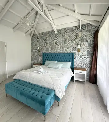 a bedroom with a blue bed with a blue couch at Hotel Arenal Vista Lodge in Fortuna