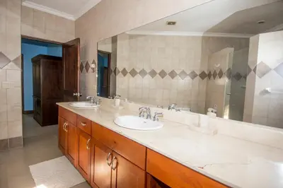 a bathroom with two sinks and a large mirror at Macaws Ocean Club Apartamento # 18 in Jacó