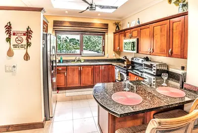 a kitchen with wooden cabinets and a counter top at Macaws Ocean Club Apartamento # 18 in Jacó